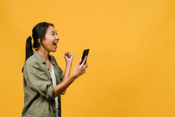 Overrasket Ung Asiatisk Dame Som Bruker Mobiltelefon Med Positivt Uttrykk – stockfoto