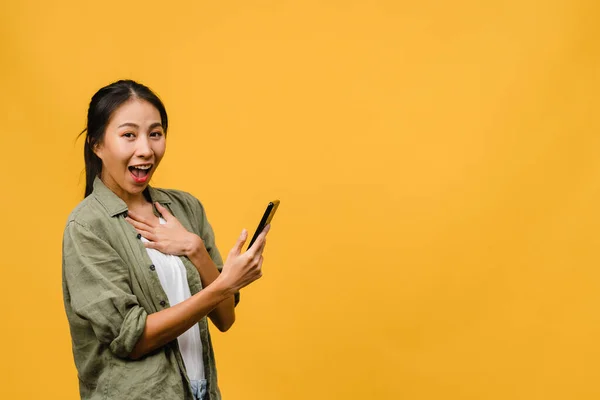 Overrasket Ung Asiatisk Dame Som Bruker Mobiltelefon Med Positivt Uttrykk – stockfoto