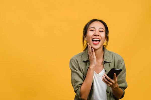Yllättynyt Nuori Aasian Nainen Joka Käyttää Matkapuhelinta Positiivisella Ilmeellä Hymyilee — kuvapankkivalokuva
