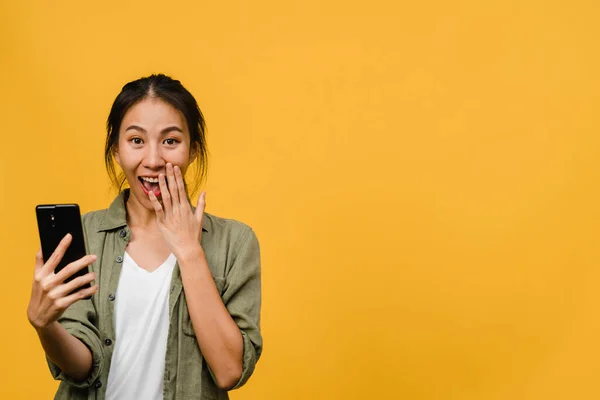 Overrasket Ung Asiatisk Dame Som Bruker Mobiltelefon Med Positivt Uttrykk – stockfoto