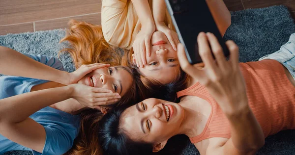 모습을 아시아 여성들이 가까이 있으면 스마트폰을 미소짓는 순간을 즐기면서 거실의 — 스톡 사진