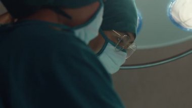 Genç Asyalı asistanlar ve hemşireler hastane ameliyathanesinde hastaya invazif ameliyat yapıyorlar. Profesyonel cerrah, sağlık ve tıbbi konseptten oluşan farklı bir ekip..
