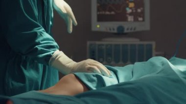 Genç Asyalı asistanlar ve hemşireler hastane ameliyathanesinde hastaya invazif ameliyat yapıyorlar. Profesyonel cerrah, sağlık ve tıbbi konseptten oluşan farklı bir ekip..