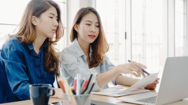 Smart casual kadınlarda çekici akıllı yaratıcı Asya iş çalışma ofisinde masasında otururken dizüstü bilgisayarda giymek. Kadın ofis kavramı iş.