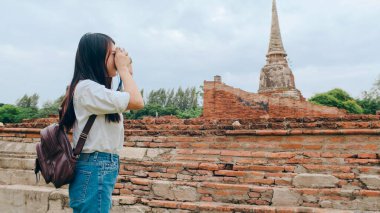 Gezgin Asyalı kadın fotoğraf çekmek için kamera kullanıyor. Tatil gezisini Ayutthaya, Tayland 'da geçiriyor. Japon bayan turist..