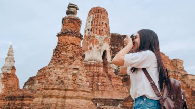 Gezgin Asyalı kadın fotoğraf çekmek için kamera kullanıyor. Tatil gezisini Ayutthaya, Tayland 'da geçiriyor. Japon bayan turist..