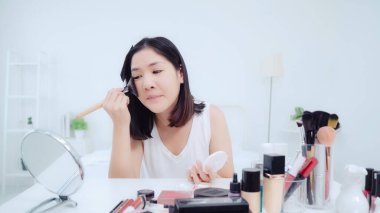 Güzellik blogger video kayıt için kamera önünde oturan güzellik kozmetik mevcut. Asyalı kadın kullanım kozmetik inceleme yapmak öğretici mutlu güzel genç sosyal ağ için canlı video yayını.