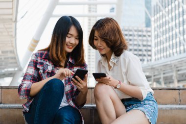 Bir grup Asyalı kadın yön bulmak için akıllı telefon kullanıyor ve Tayland 'ın Bangkok kentindeki şehir haritasına bakıyorlar. Tayland konseptinde yaşam tarzı turist seyahati.