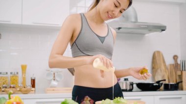 Genç Asyalı kadın güzel kadın kullanım sebze salatası evde fit vücut için hazırlanıyor mutfakta görünümlü tarifi için cep telefonu kullanırken salata sağlıklı yemek yapma. Sağlıklı gıda kavramı.