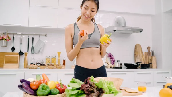 Nuori Aasialainen Nainen Juo Appelsiinimehua Tekemällä Salaattia Keittiössä Kaunis Nainen — kuvapankkivalokuva
