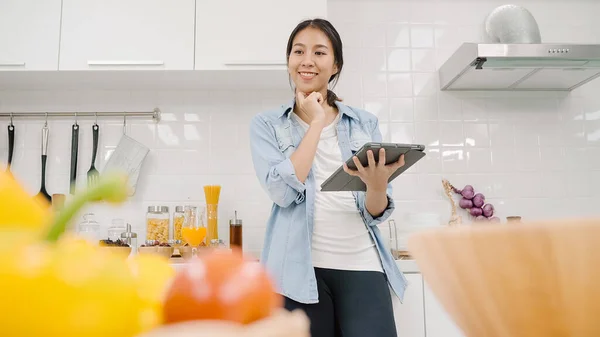 Lykkelig Asiatisk Kvinne Som Bruker Tablett Til Oppskrift Mens Hun – stockfoto