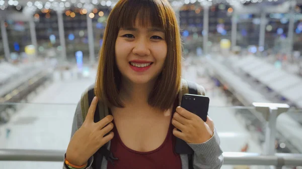 Onnellinen Aasialainen Nainen Hymyilee Kameralle Oleskellessaan Terminaalissa Kansainvälisellä Lentokentällä Naisturisti — kuvapankkivalokuva