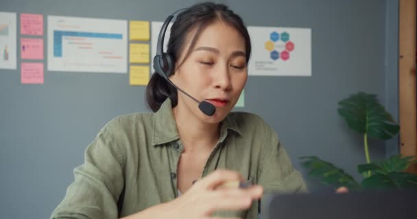 Close up Asie podnikatelka pomocí notebooku mluvit s kolegy ve videohovoru při práci z domu v obývacím pokoji. Zákaznický agent nebo call centrum, společenské distancování, karanténa pro koronavirus.