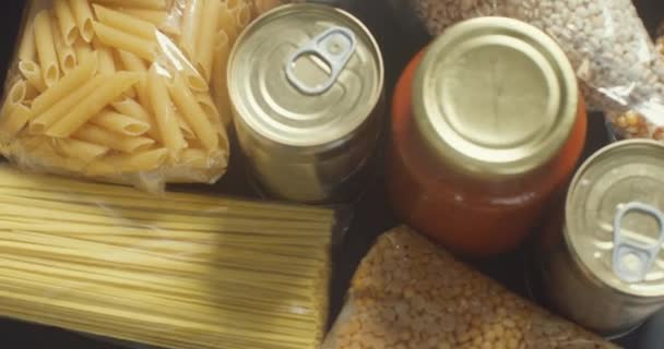 油で寄付食品 缶詰食品 パスタ 木製のテーブルの上にトマトペースト コロナウイルスと隔離の概念 — ストック動画