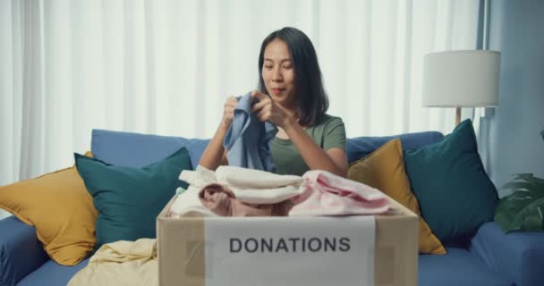 Genç Asya Gönüllü Genç Kız Oturma Odasındaki Bağış Kutularına Giysi — Stok video