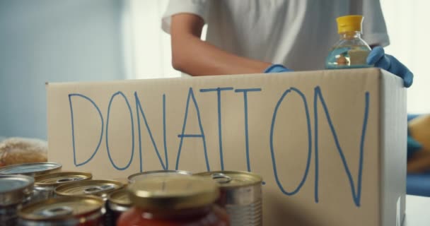 年轻的亚洲少女志愿者在慈善基金会工作时 戴着手套 将食物和饮料捐赠到捐赠纸盒中 社会工作者 粮食银行和验尸官概念 — 图库视频影像