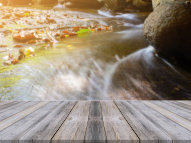 Wooden board empty table in front of blurred background. Perspective brown wood over blur waterfall in forest - can be used for display or montage your products. vintage filtered image.