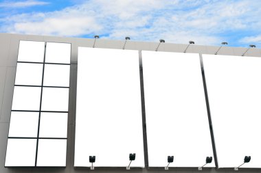 Blank poster billboard wall with copy space for your text message or content in modern shopping mall on cloudy day.