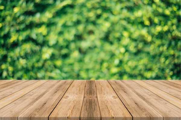 Holzbrett leerer Tisch vor verschwommenem Hintergrund. Perspektive braunes Holz über unscharfe Bäume im Wald - kann für die Anzeige oder Montage Ihrer Produkte verwendet werden. Frühlingszeit. — Stockfoto