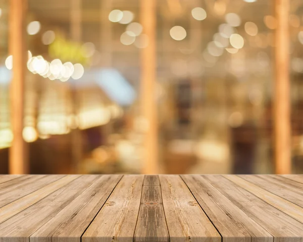 Placa de madeira mesa vazia na frente do fundo borrado. Perspectiva de madeira marrom sobre borrão no café pode ser usado para exibir ou montar seus produtos.Preparar para exibir o produto . — Fotografia de Stock