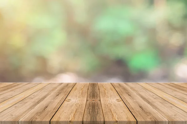 Holzbrett leerer Tisch vor verschwommenem Hintergrund. Perspektive braunes Holz über unscharfe Bäume im Wald - kann für die Anzeige oder Montage Ihrer Produkte verwendet werden. Frühlingszeit. — Stockfoto