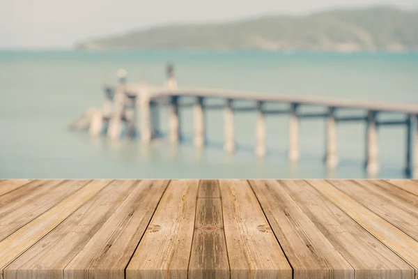Mesa de madera sobre fondo borroso azul mar y arena blanca playa, tono vintage - se puede utilizar para productos de exhibición o montaje — Foto de Stock