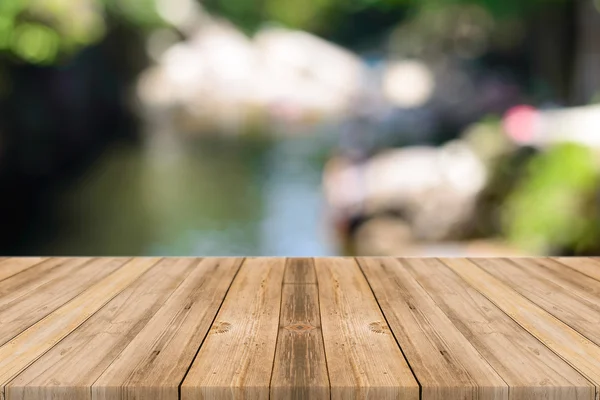 Holzbrett leerer Tisch vor verschwommenem Hintergrund. Perspektive graues Holz über unscharfe Bäume im Wald - kann für die Anzeige oder Montage Ihrer Produkte verwendet werden. Frühlingszeit. — Stockfoto