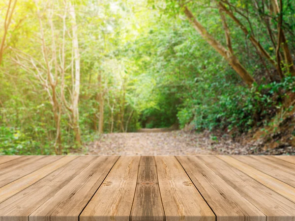 Wooden board empty table in front of blurred background. Perspective brown wood over blur trees in forest - can be used for display or montage your products. vintage filtered image.