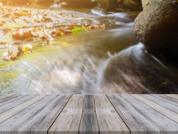 Wooden board empty table in front of blurred background. Perspective brown wood over blur waterfall in forest - can be used for display or montage your products. vintage filtered image.