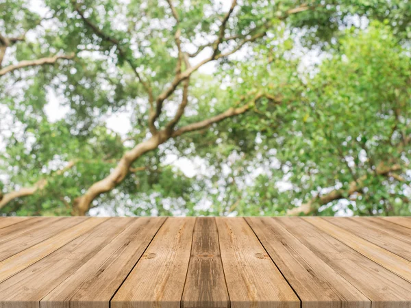 Wooden board empty table in front of blurred background. Perspective brown wood over blur trees in forest - can be used for display or montage your products. vintage filtered image.