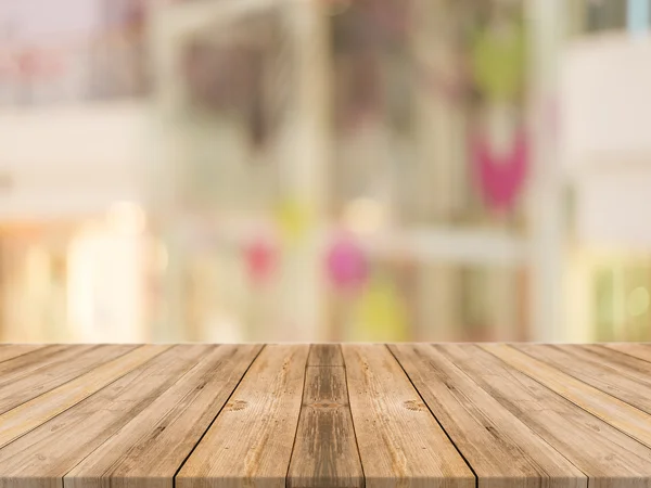 Tablero de madera mesa vacía en frente de fondo borroso. Perspectiva de madera marrón sobre desenfoque tienda en el centro comercial - se puede utilizar para mostrar o montar sus productos . Fotos de stock