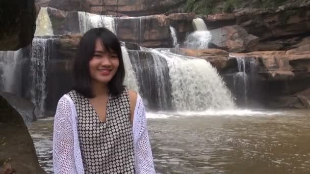 Hermosa joven mujer relajándose en un maravilloso bosque cerca de la cascada . — Vídeos de Stock