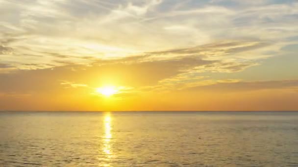 4K Jour à Nuit Time-lapse : Timelapse de nuages traversant le ciel étonnant au-dessus de la mer ou de l'océan au coucher du soleil. Les nuages traversent lentement de gauche à droite. Les nuages se reflètent dans l'eau .