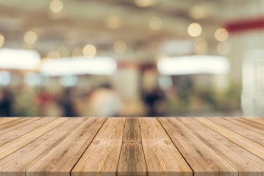 Restorandaki tahta masa bulanık arka planda. Kahve dükkanında bulanık kahverengi ahşap üzerine perspektif - ürünlerinizi görüntülemek veya montajlamak için kullanılabilir. Prodüksiyon için modelleyin. Vintage filtresi.