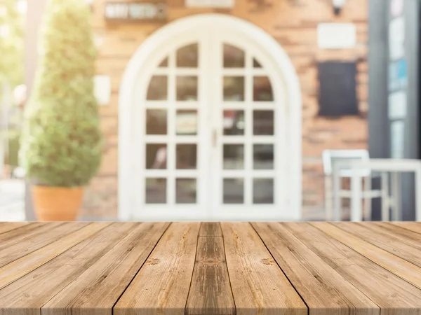 Tablero de madera mesa vacía en frente de fondo borroso. Perspectiva de madera marrón sobre desenfoque en la cafetería - se puede utilizar para mostrar o montar sus productos.Prepárese para mostrar producto.Filtro vintage . — Foto de Stock