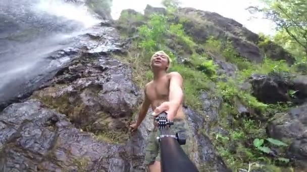 Hombre caminando ir a selfie cerca de cascada . — Vídeos de Stock