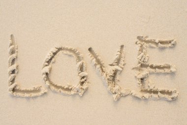Aşk mesajı kuma yazılmıştır. Plaj arka plan.
