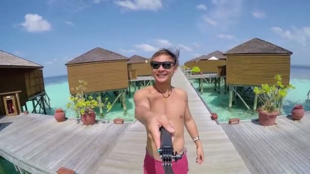 Веселий чоловік приймає selfie фотографію себе на екзотичний відпочинок, морським курортом на Мальдівах. — стокове відео