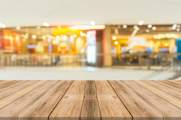 Holzbrett leerer Tisch vor verschwommenem Hintergrund. Perspektive braunes Holz über Unschärfe im Restaurant - kann für die Anzeige oder Montage Ihrer Produkte verwendet werden.. — Stockfoto