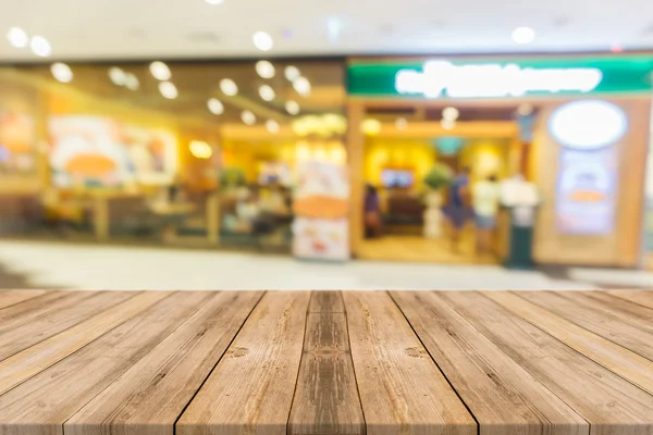 Träskiva tomma bord framför suddig bakgrund. Perspektiv brunt trä över oskärpa i restaurang - kan användas för visning eller montage dina produkter. Håna upp för visning av produkten. — Stockfoto