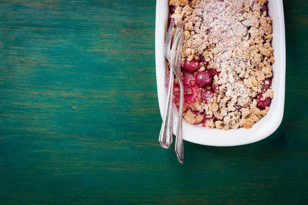 Torta di ciliegie fresche fatte in casa con farina integrale e zucchero a velo su sfondo verde vintage in legno — Foto Stock