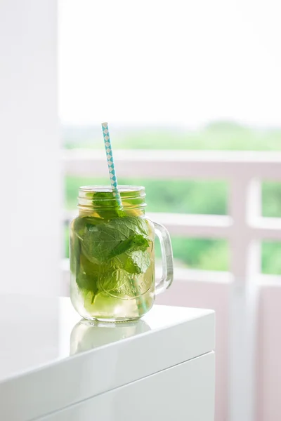 Sabrosa bebida colorida con té verde frío, menta y limón en un frasco de vidrio —  Fotos de Stock