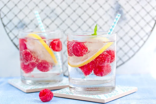 Cocktail maison au citron framboise froid d'été avec de l'eau pétillante et glace concassée dans des verres, gros plan — Photo