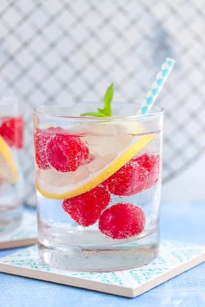 Cocktail maison au citron framboise froid d'été avec eau pétillante et glace concassée dans des verres — Photo