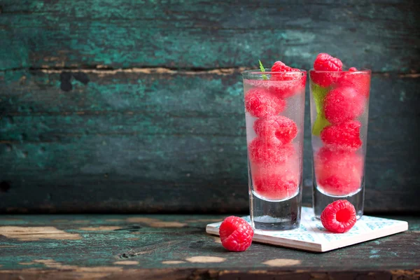 Cocktail de framboises froides maison avec glace, sirop de baies et alcool dans des verres sur un fond vintage — Photo