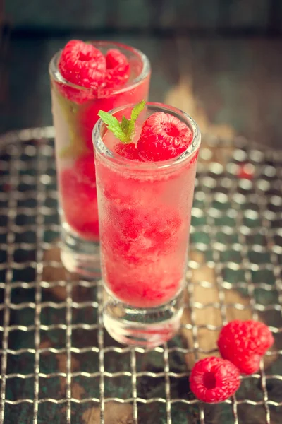 Cocktail de framboises froides maison avec glace, sirop de baies et alcool dans des verres sur un fond vintage — Photo