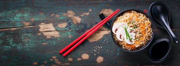 Fideos asiáticos con verduras y champiñones, salsa de soja, palos sobre un fondo oscuro, vista superior con espacio para copiar —  Fotos de Stock