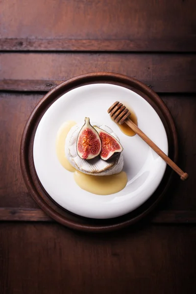 Camembert assado com figos frescos e mel em um fundo de madeira — Fotografia de Stock