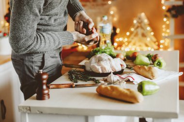 Genç adam Noel için çiğ tavuk pişirir. Tatil arkaplanı