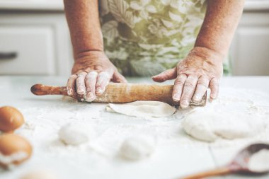 Evde pizza ya da ekmek pişirmek için hamur yoğuran bir kadın var. Ev yemeği konsepti. Yaşam biçimi